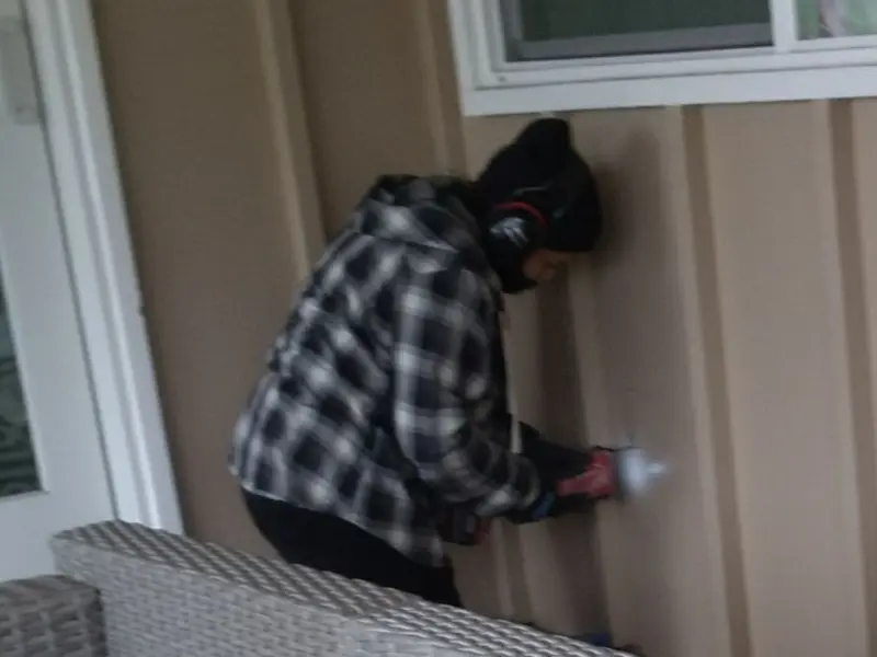 Professional electrician installing an exterior outlet in Honeygo